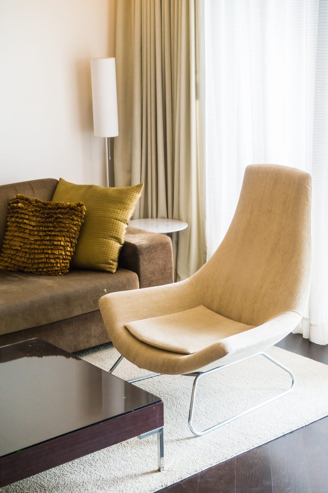 An original photo of a beige armchair in a real living room, before Reviz staging